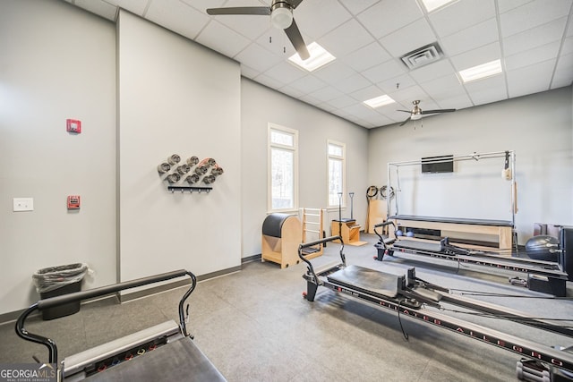 workout room featuring ceiling fan and a drop ceiling