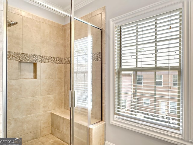 bathroom with a stall shower, a wealth of natural light, and crown molding