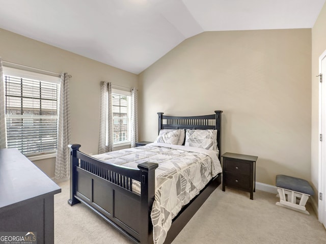 bedroom with vaulted ceiling, baseboards, and light colored carpet