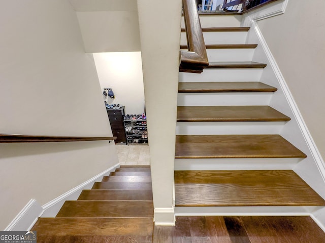 staircase featuring baseboards and wood finished floors