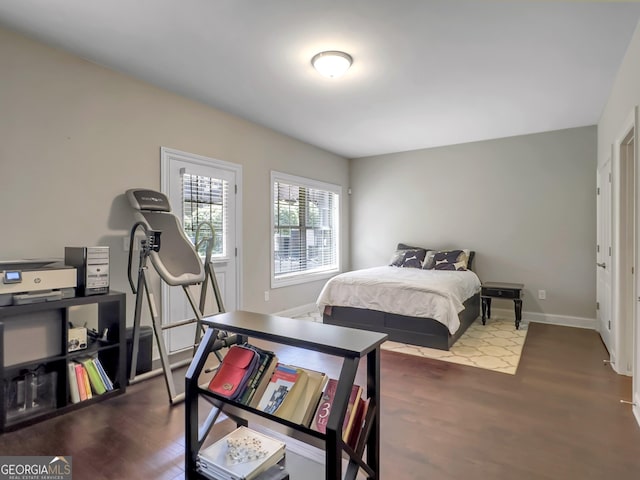 bedroom with dark wood finished floors and baseboards