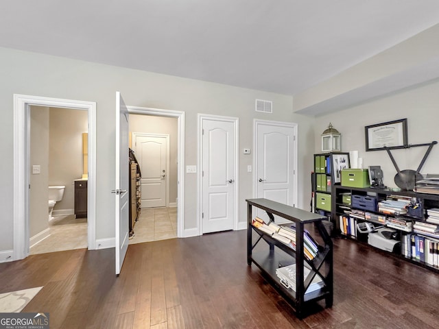 office with visible vents, baseboards, and wood finished floors