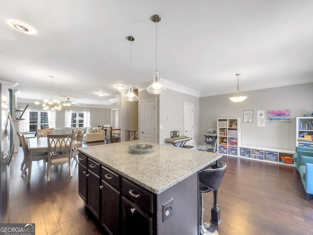 kitchen featuring a center island, dark wood finished floors, a breakfast bar area, hanging light fixtures, and open floor plan