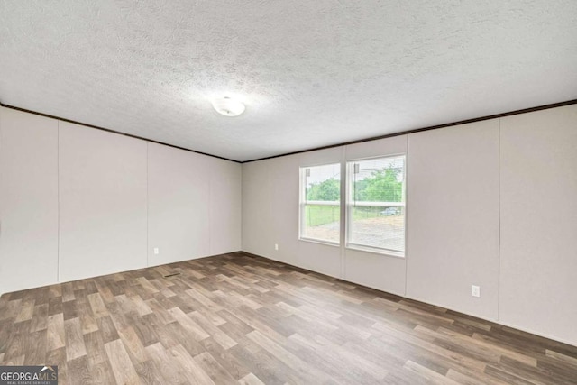 spare room with wood-type flooring and a textured ceiling