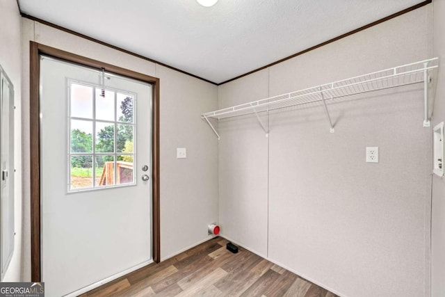 laundry area featuring wood-type flooring and a textured ceiling