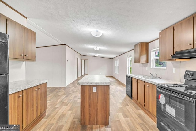 kitchen with exhaust hood, light wood-type flooring, a kitchen island, and black appliances