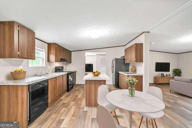 kitchen with vaulted ceiling, light hardwood / wood-style flooring, ornamental molding, and black appliances