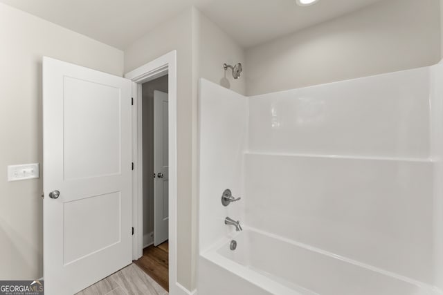 bathroom with hardwood / wood-style floors and  shower combination