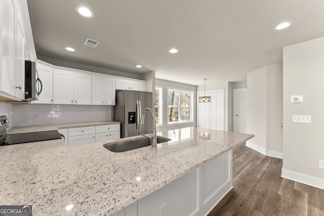 kitchen featuring sink, light stone countertops, appliances with stainless steel finishes, dark hardwood / wood-style flooring, and white cabinetry