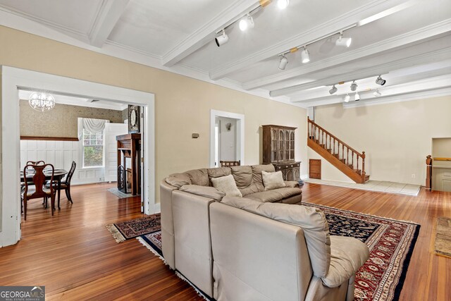 living room with beamed ceiling, hardwood / wood-style floors, track lighting, and a fireplace