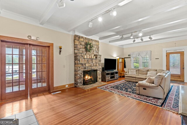 living room featuring beam ceiling, hardwood / wood-style floors, and ornamental molding