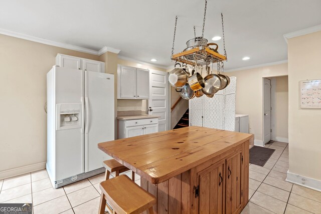 kitchen with light tile patterned floors, stainless steel appliances, white cabinetry, and sink