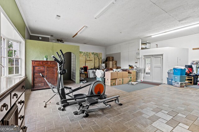 living area featuring hardwood / wood-style flooring, ceiling fan, ornamental molding, and a textured ceiling