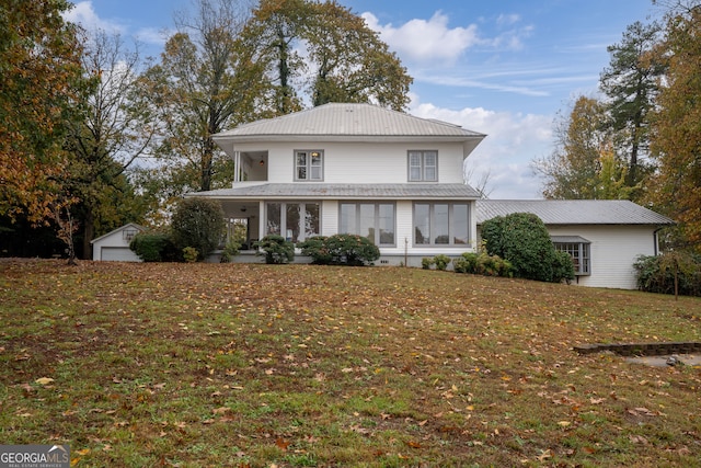 front of property with a front lawn, an outdoor structure, and a garage