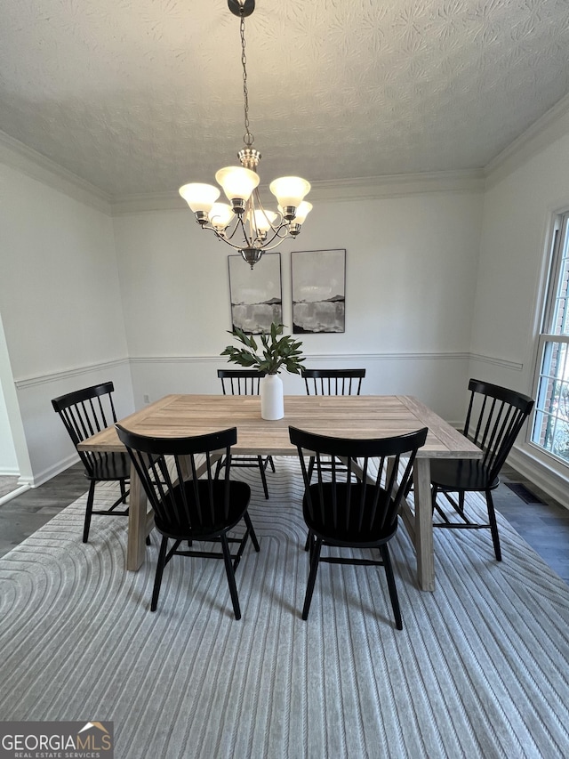 dining space with crown molding, dark hardwood / wood-style floors, a textured ceiling, and an inviting chandelier