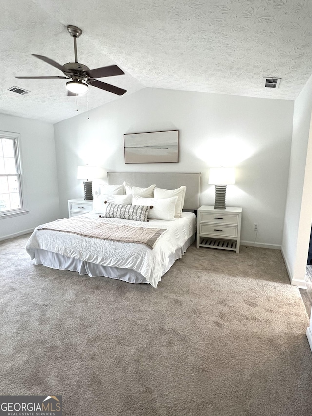 carpeted bedroom with lofted ceiling, ceiling fan, and a textured ceiling