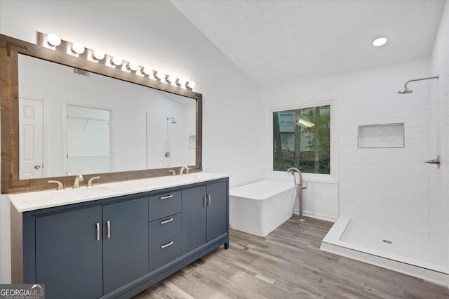 bathroom with lofted ceiling, vanity, hardwood / wood-style flooring, and shower with separate bathtub