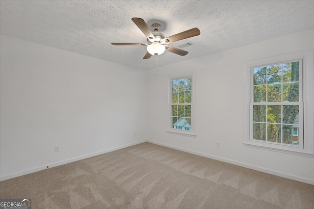 carpeted empty room featuring ceiling fan and a textured ceiling