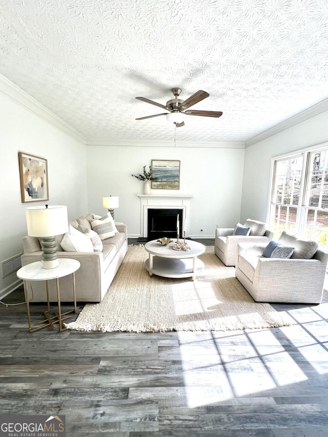 living room with crown molding, ceiling fan, hardwood / wood-style floors, and a textured ceiling