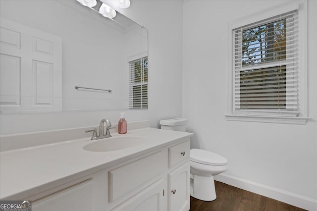 bathroom with hardwood / wood-style flooring, vanity, and toilet