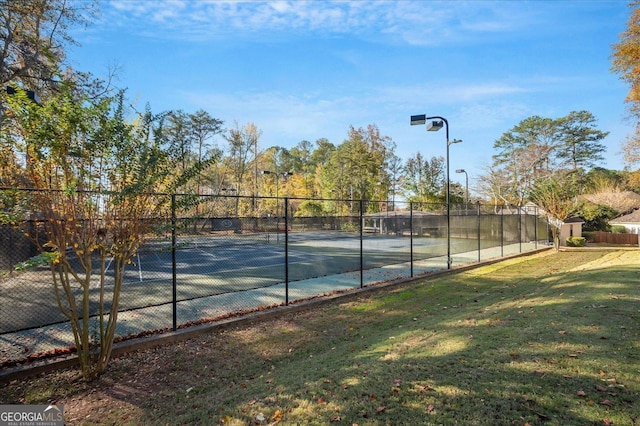 view of tennis court with a lawn