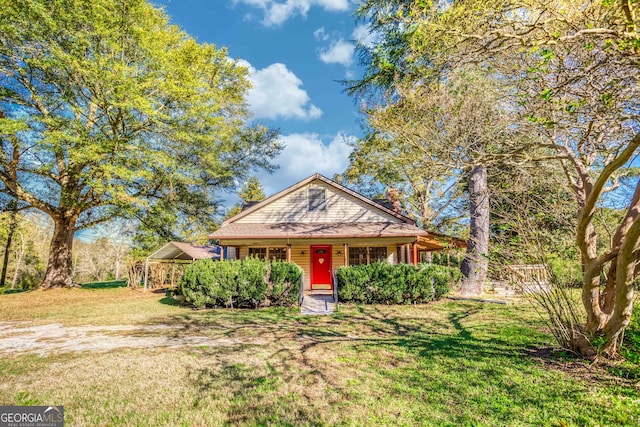 view of front of home featuring a front yard, a porch, and a carport