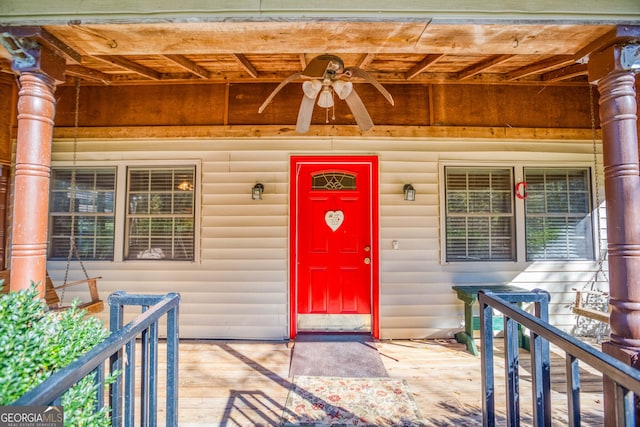 view of exterior entry with ceiling fan and covered porch