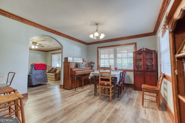 dining space featuring crown molding, ceiling fan with notable chandelier, and light wood-type flooring