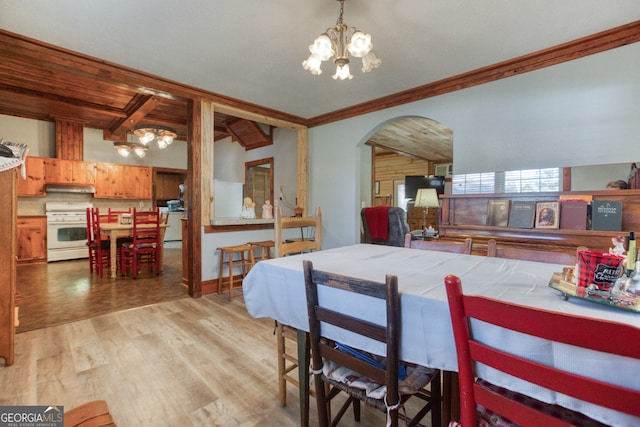 dining space with vaulted ceiling with beams, light wood-type flooring, crown molding, and a chandelier