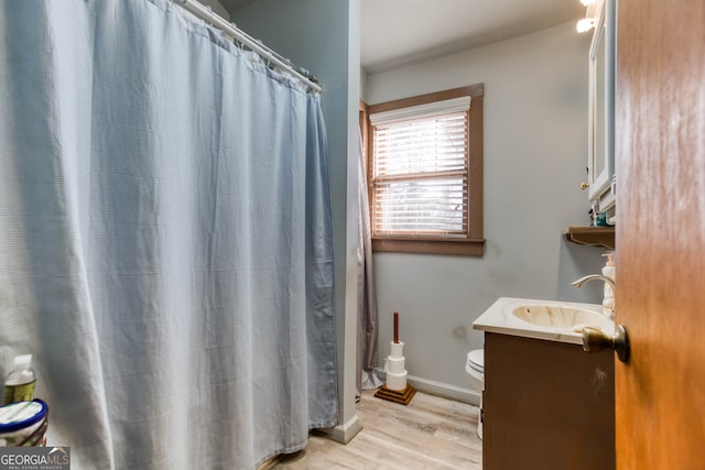 bathroom featuring toilet, vanity, a shower with shower curtain, and hardwood / wood-style flooring