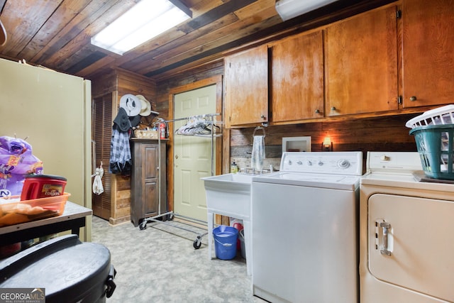 laundry room featuring washer and clothes dryer, wood walls, cabinets, and wood ceiling