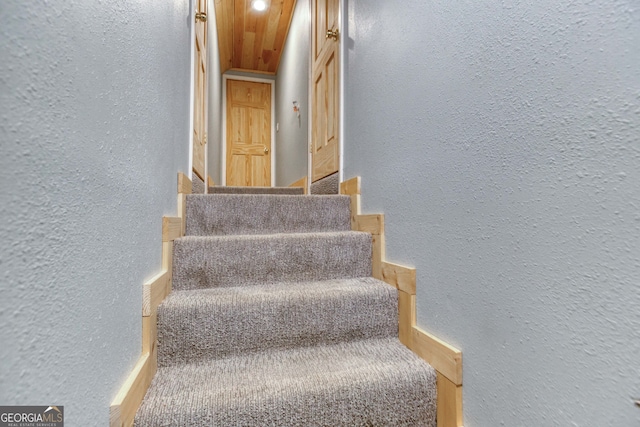 stairway with wooden ceiling