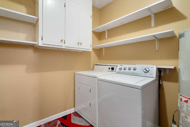 laundry area with cabinets, washing machine and dryer, and gas water heater