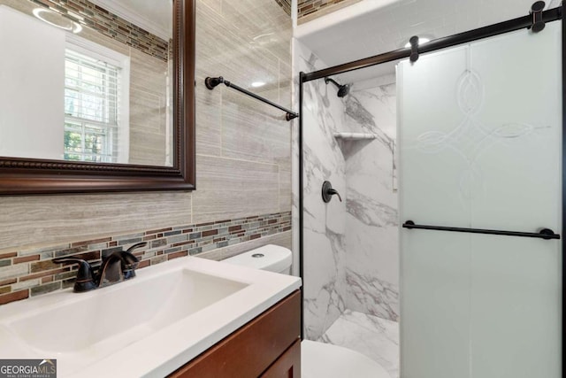 bathroom with vanity, toilet, a shower with shower door, and backsplash