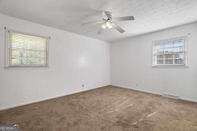 spare room featuring carpet flooring, ceiling fan, and a textured ceiling