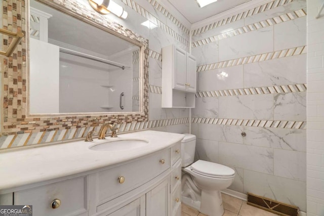 bathroom with walk in shower, tile patterned floors, toilet, vanity, and tile walls