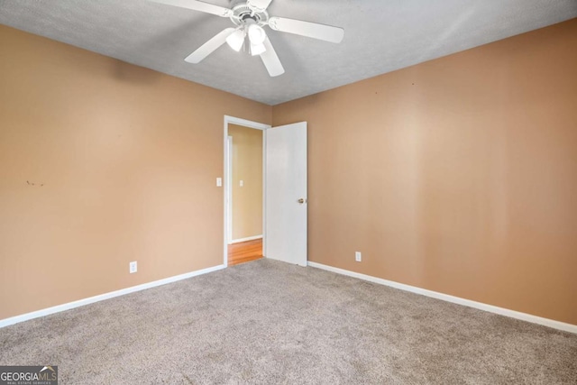 carpeted empty room with ceiling fan and a textured ceiling