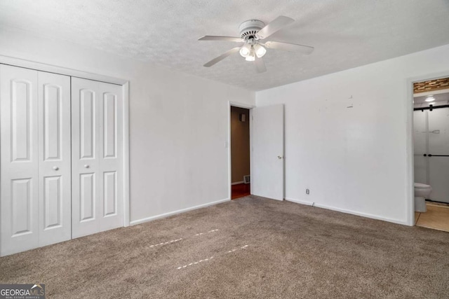 unfurnished bedroom with carpet, connected bathroom, and ceiling fan