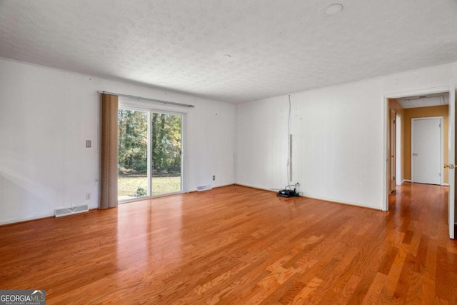 empty room featuring light hardwood / wood-style floors and a textured ceiling