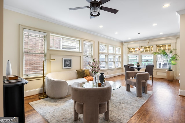 sitting room featuring ceiling fan, ornamental molding, and wood-type flooring