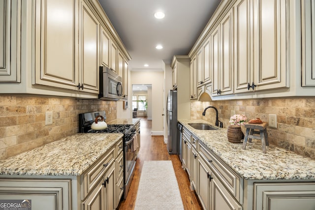 kitchen with appliances with stainless steel finishes, sink, and cream cabinets