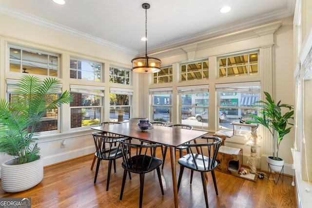 dining space featuring wood-type flooring and ornamental molding