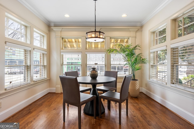 dining space with ornamental molding and dark hardwood / wood-style floors