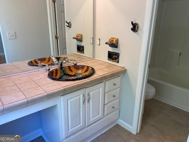 bathroom with tile patterned flooring, vanity, and toilet