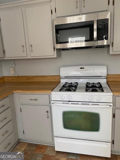 kitchen with white cabinets and white range with gas stovetop