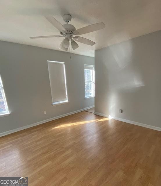 spare room featuring light hardwood / wood-style floors, a wealth of natural light, and ceiling fan