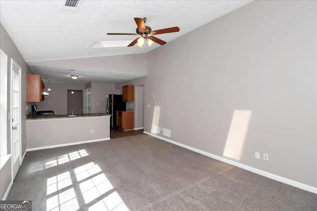 unfurnished living room featuring vaulted ceiling, dark carpet, and ceiling fan