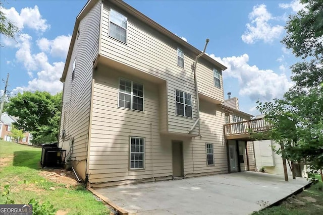 back of house featuring a deck and a patio area