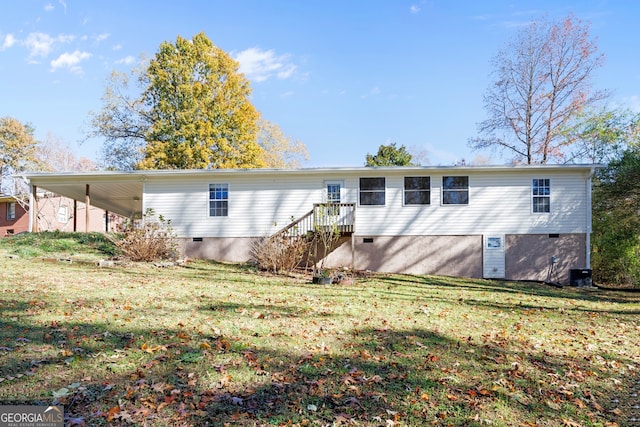 back of property with a lawn, a carport, and central air condition unit