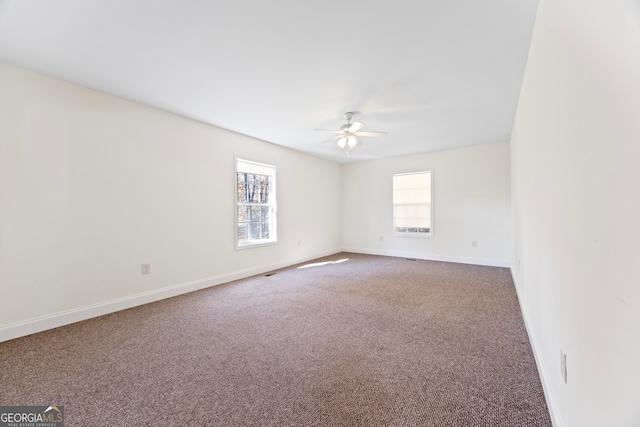 empty room with ceiling fan, carpet floors, and a healthy amount of sunlight